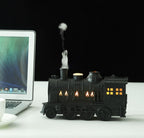 Matte Black train humidifier puffing mist on a desk
